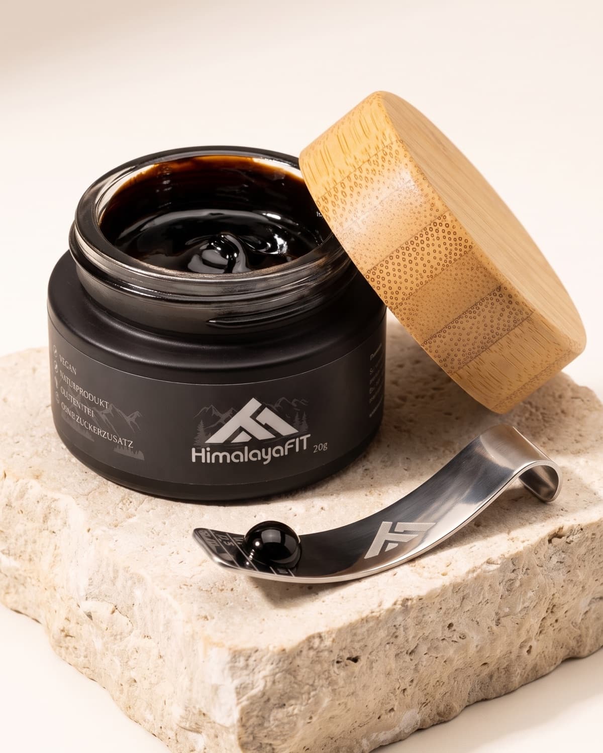 HimalayaFIT Glastiegel mit Shilajit-Harz, Bambusdeckel und Dosierlöffel auf einem Naturstein